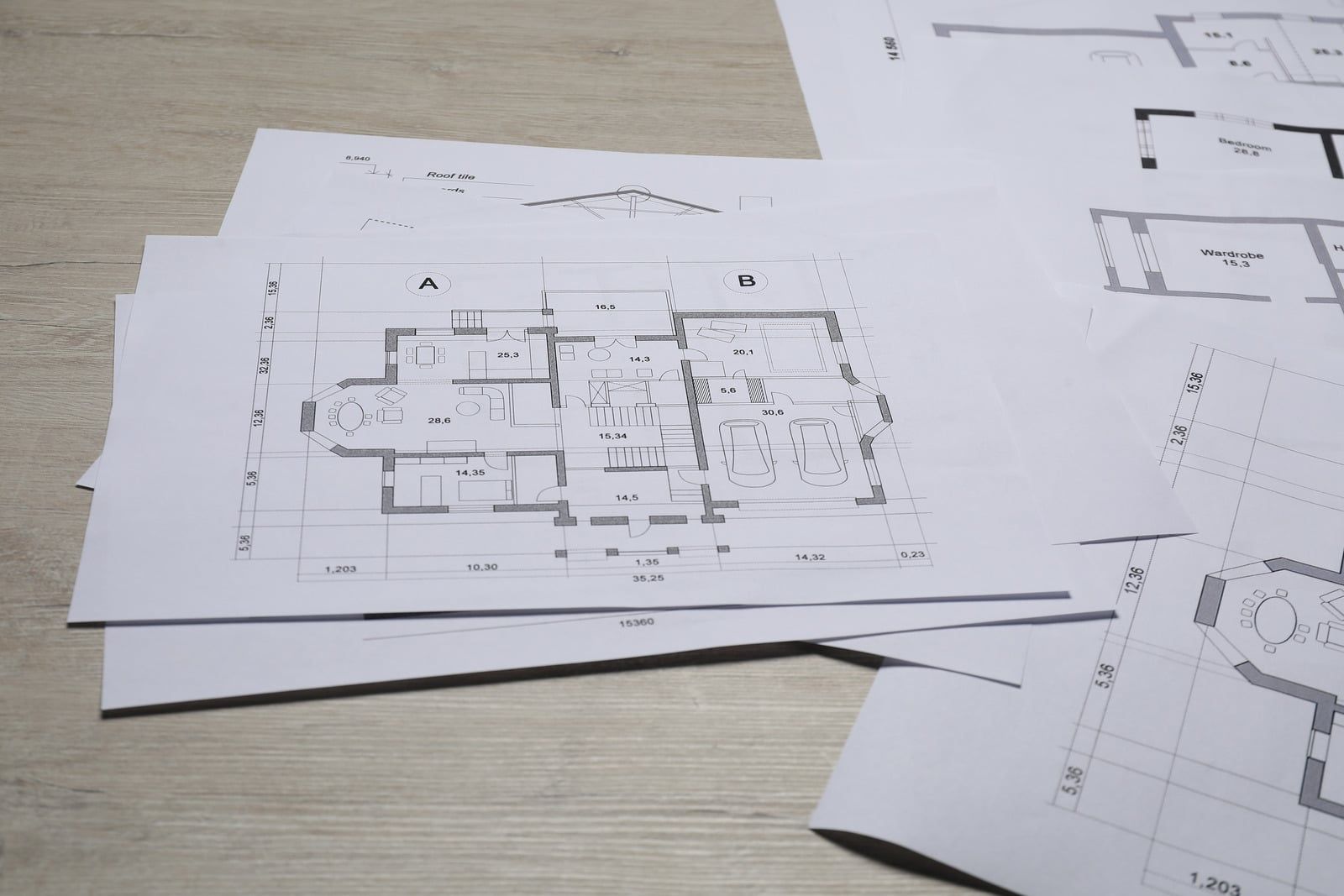 Plantegninger af et hus spredt ud på et bord
